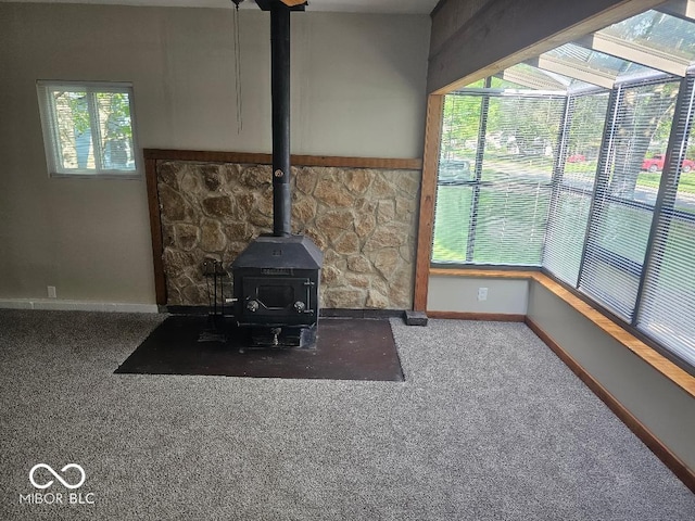 706 Alexander St, Greenwood, IN 46143 - unfurnished living room with a wood stove, baseboards, and carpet floors