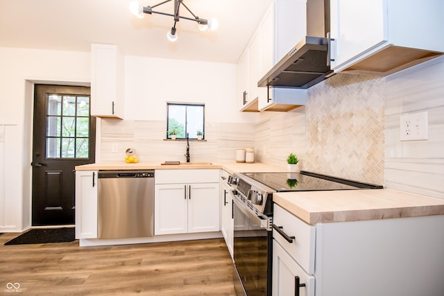 648 Market St, Hope, IN 47246 - kitchen featuring stainless steel appliances, light wood-type flooring, a sink, and wall chimney range hood