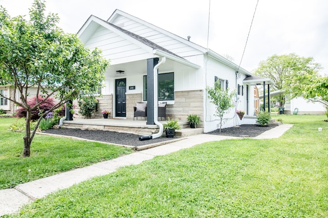 648 Market St, Hope, IN 47246 - view of front of house featuring a front yard, a porch, and stone siding