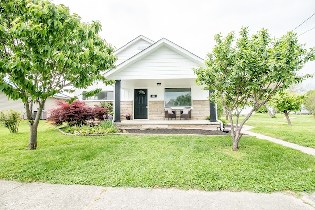 648 Market St, Hope, IN 47246 - view of front of home with stone siding, a front lawn, and covered porch