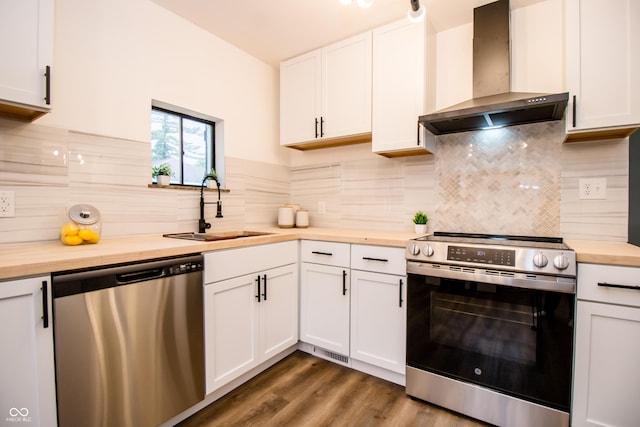 648 Market St, Hope, IN 47246 - kitchen with wooden counters, appliances with stainless steel finishes, wall chimney range hood, a sink, and white cabinets