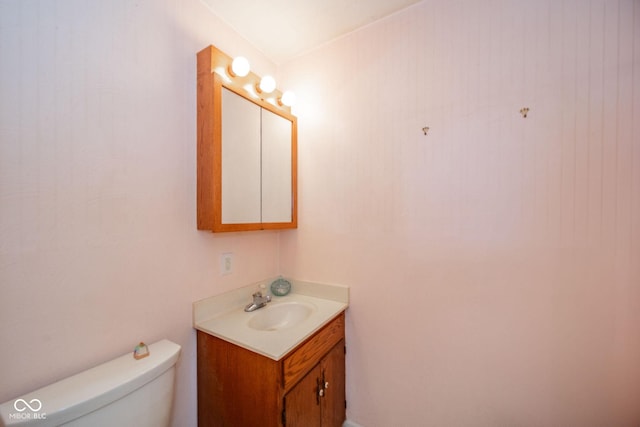 half bath featuring toilet and vanity