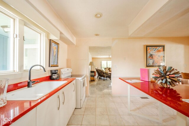 kitchen with a sink, white electric range oven, white cabinets, and light tile patterned floors