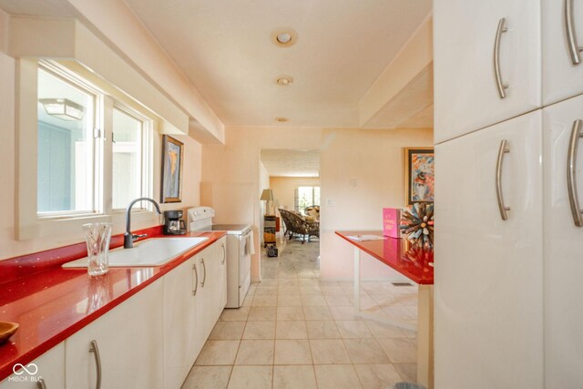 kitchen with a sink, white electric stove, and white cabinetry