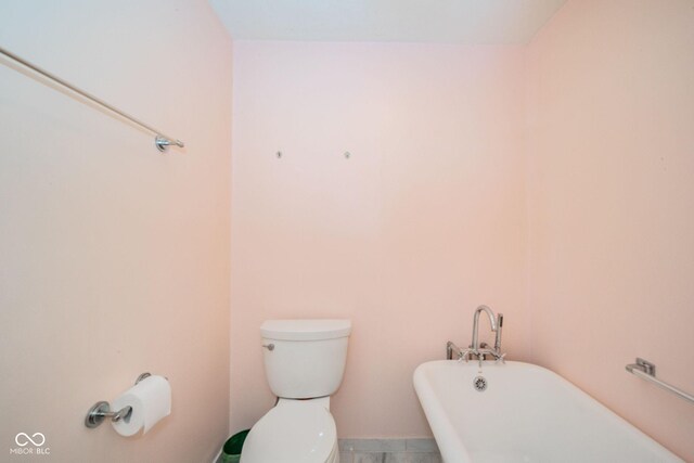 bathroom featuring a freestanding bath and toilet