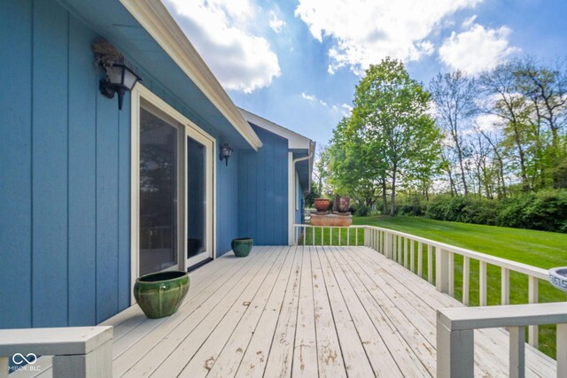 wooden terrace featuring a yard