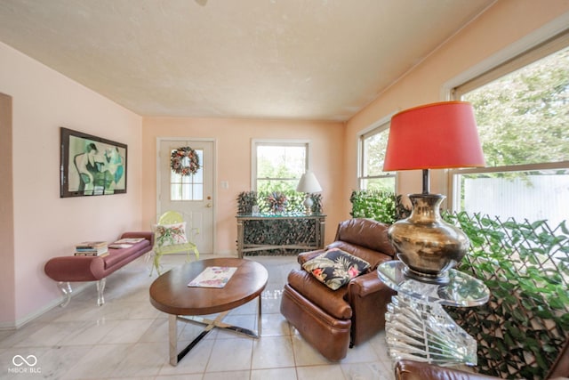 tiled living area with healthy amount of natural light and baseboards