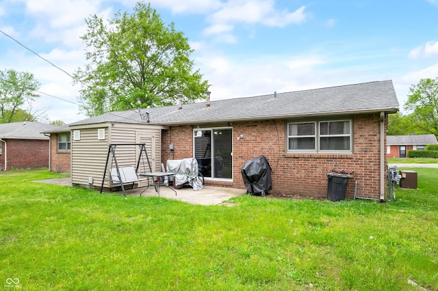 5120 Apache Ct, Columbus, IN 47203 - back of property with a patio, brick siding, a yard, and roof with shingles