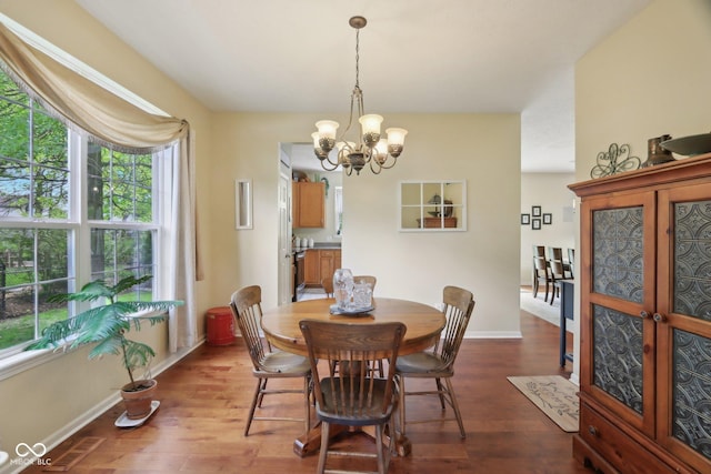 dining area with a chandelier, dark wood-style flooring, and baseboards