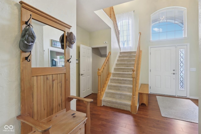 entryway with wood finished floors and stairs