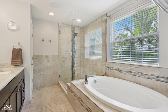 bathroom featuring a garden tub, healthy amount of natural light, vanity, and a shower stall