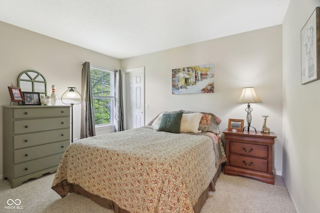 bedroom with light carpet and baseboards