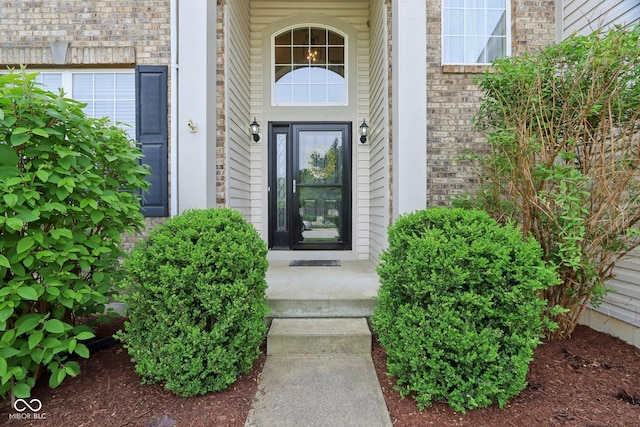 property entrance featuring brick siding