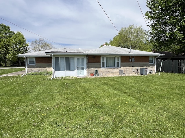 2927 E 8th St, Anderson, IN 46012 - rear view of property featuring central air condition unit, stone siding, and a yard