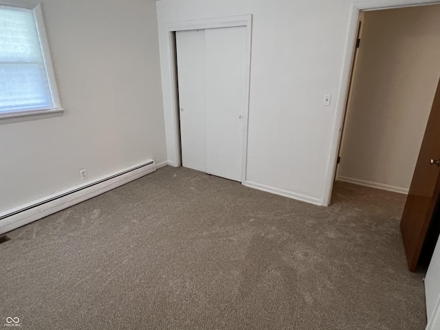 2927 E 8th St, Anderson, IN 46012 - unfurnished bedroom featuring carpet, a closet, a baseboard heating unit, and baseboards
