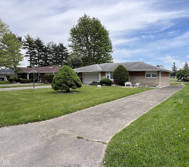 2927 E 8th St, Anderson, IN 46012 - ranch-style house with a front yard, stone siding, an attached garage, and concrete driveway