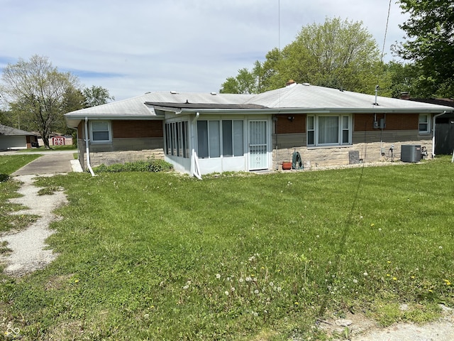 2927 E 8th St, Anderson, IN 46012 - back of property featuring stone siding, a sunroom, a yard, and cooling unit