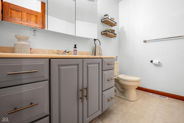 bathroom with toilet, baseboards, and vanity