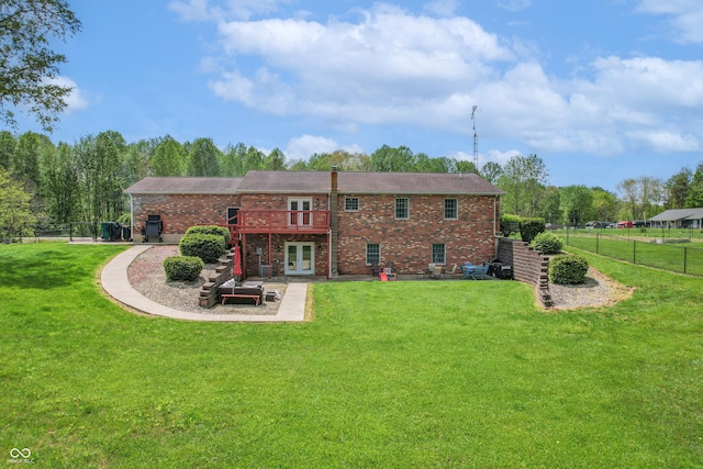 rear view of property with french doors, brick siding, and a deck