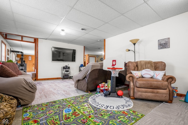 living area with baseboards and a drop ceiling