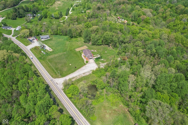 aerial view of property and surrounding area featuring a forest
