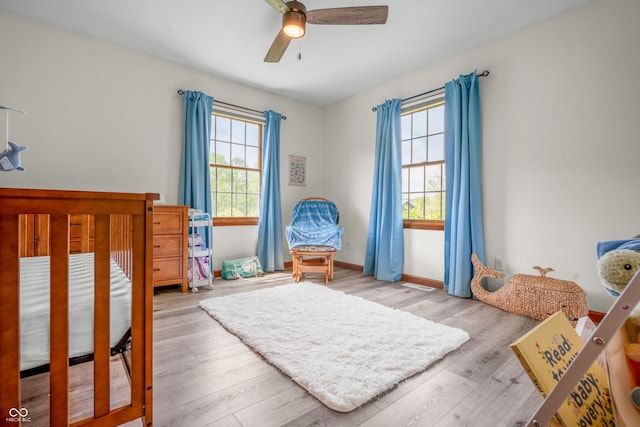 bedroom featuring wood finished floors, baseboards, and ceiling fan