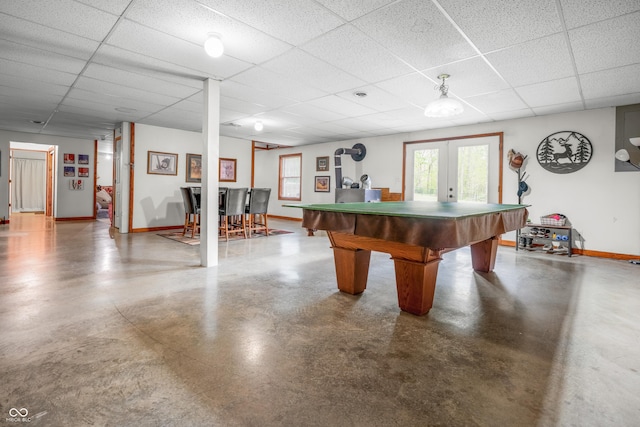 rec room with a paneled ceiling, concrete flooring, baseboards, french doors, and billiards