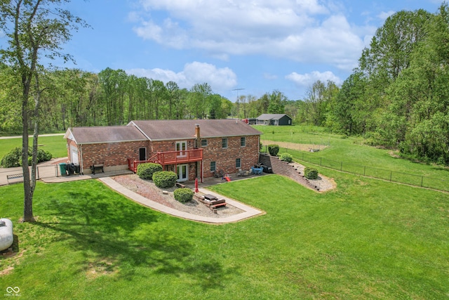 view of front of house featuring a garage, brick siding, a wooden deck, and driveway