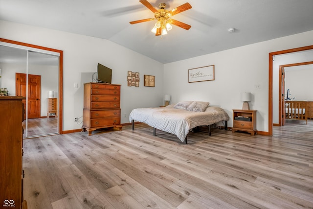 bedroom with lofted ceiling, wood finished floors, a closet, baseboards, and a ceiling fan