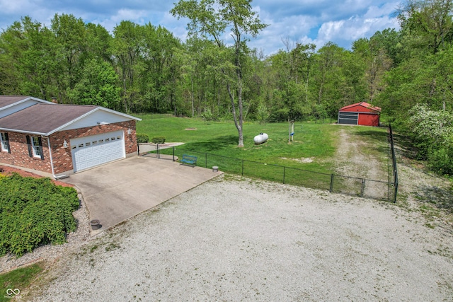 view of yard featuring driveway and a wooded view