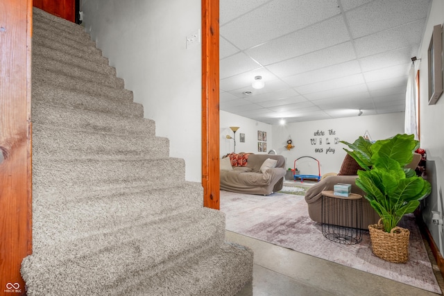 stairs with a paneled ceiling