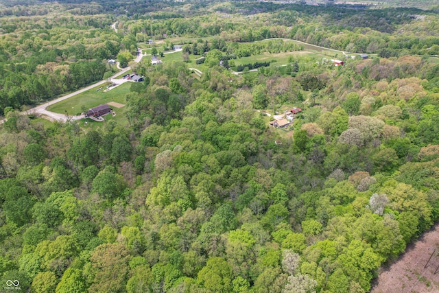 view of property location with a forest