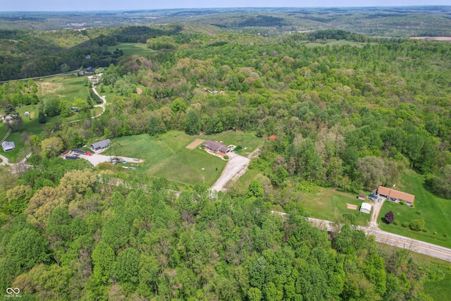 aerial view of property and surrounding area with a heavily wooded area