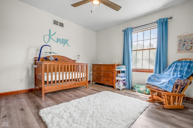 bedroom featuring wood finished floors, baseboards, and a ceiling fan