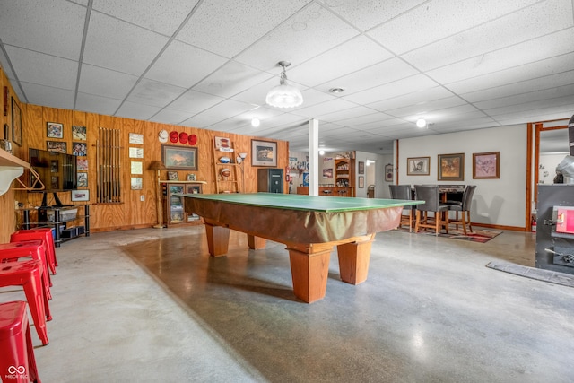 recreation room featuring concrete floors, billiards table, a paneled ceiling, baseboards, and wooden walls