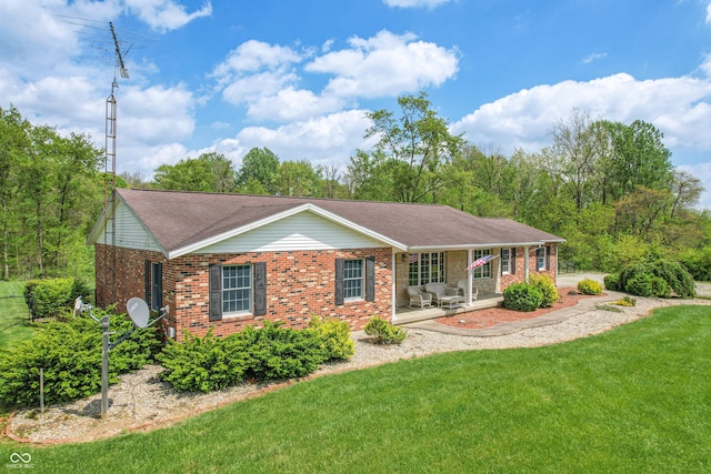 back of house with a yard, brick siding, and a shingled roof