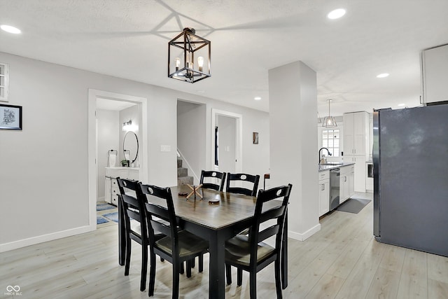 dining space featuring light wood-type flooring, stairs, recessed lighting, baseboards, and a chandelier