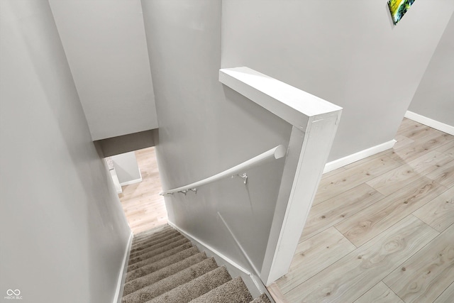 stairway with wood finished floors and baseboards