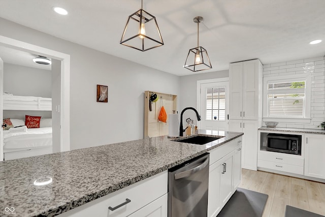 kitchen featuring built in microwave, dishwasher, a sink, healthy amount of natural light, and recessed lighting