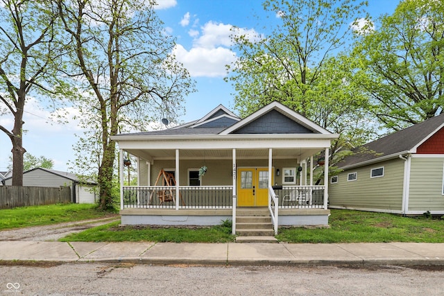 view of front of house with covered porch and fence