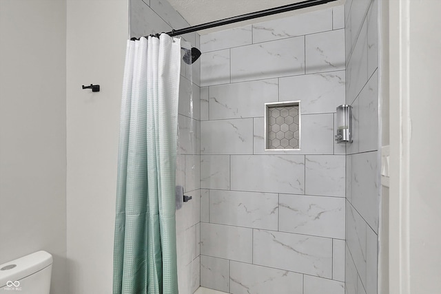 full bath with tiled shower and toilet