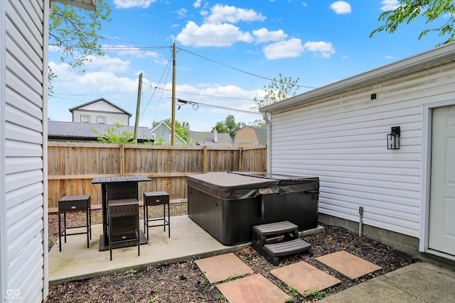 view of patio / terrace featuring a hot tub, fence, and outdoor dining space
