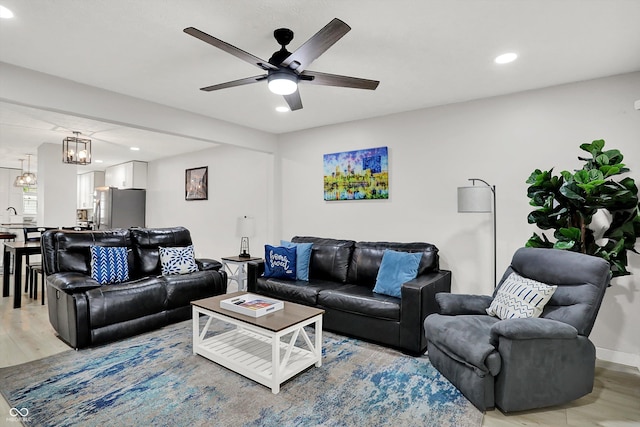 living area featuring recessed lighting, light wood-type flooring, a chandelier, and ceiling fan