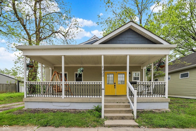 view of front of home featuring covered porch and brick siding