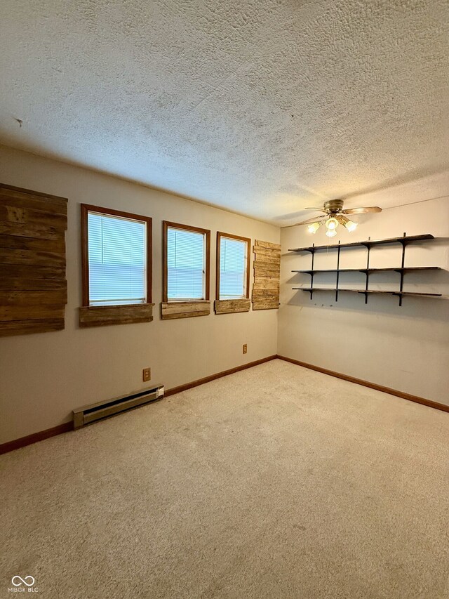 carpeted empty room featuring baseboard heating, baseboards, a textured ceiling, and a ceiling fan