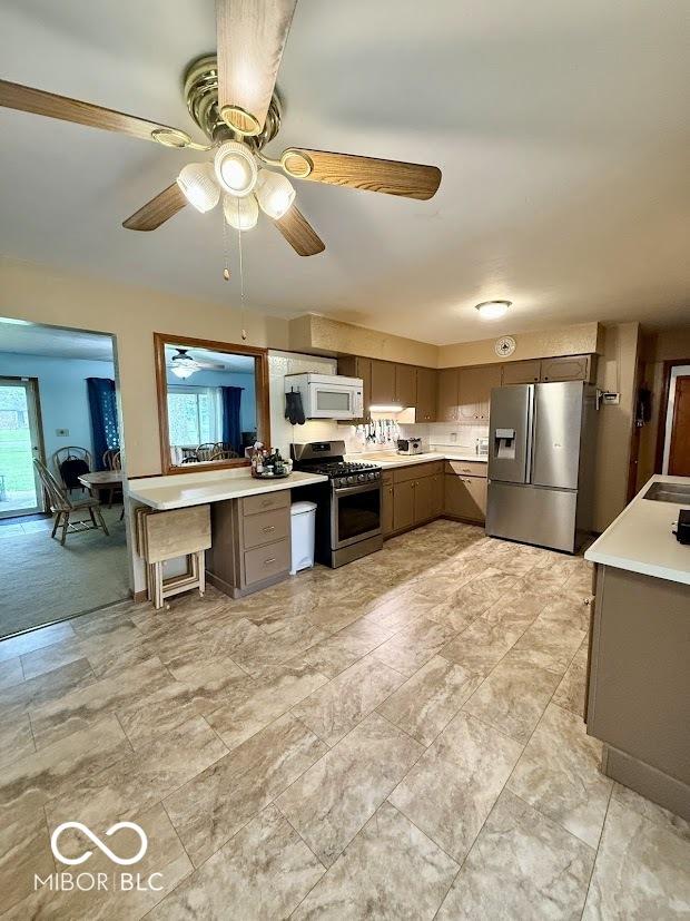 kitchen with stainless steel appliances, plenty of natural light, and light countertops