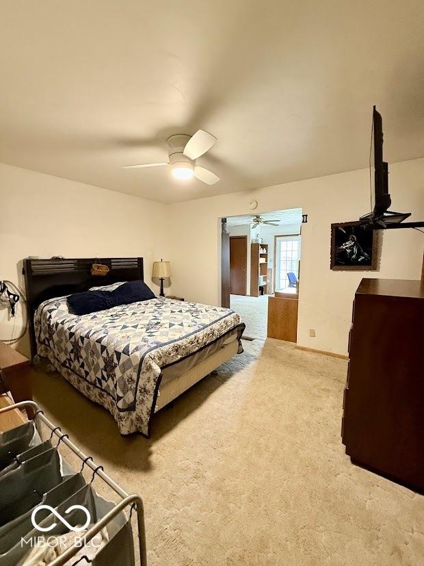 carpeted bedroom with a ceiling fan and baseboards