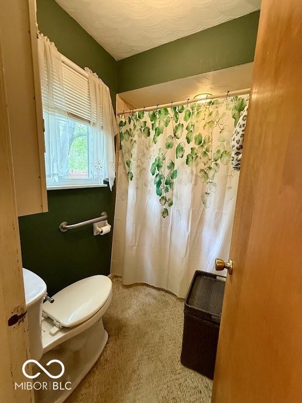 full bath with toilet and curtained shower
