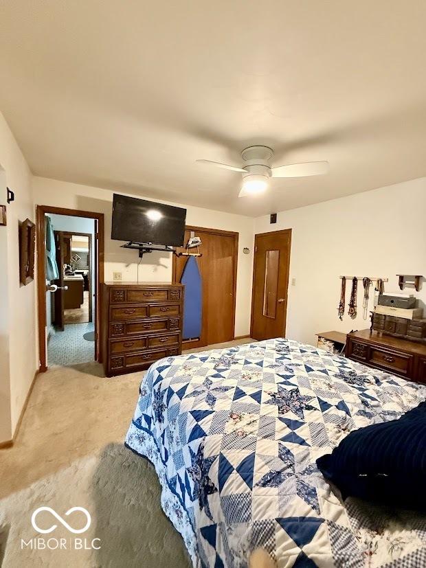 bedroom with light colored carpet and a ceiling fan