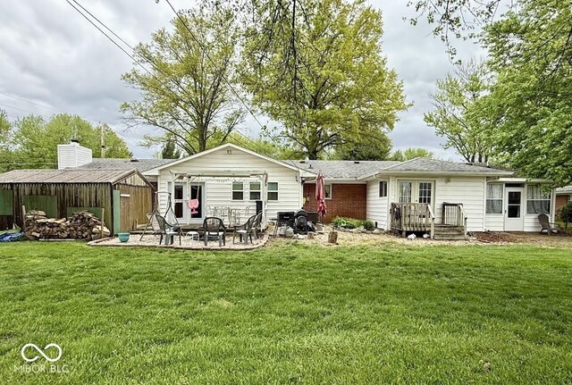 rear view of property with a yard and a patio